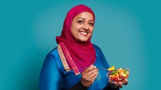 lady of south Asian descent eating a bowl of fruit salad
