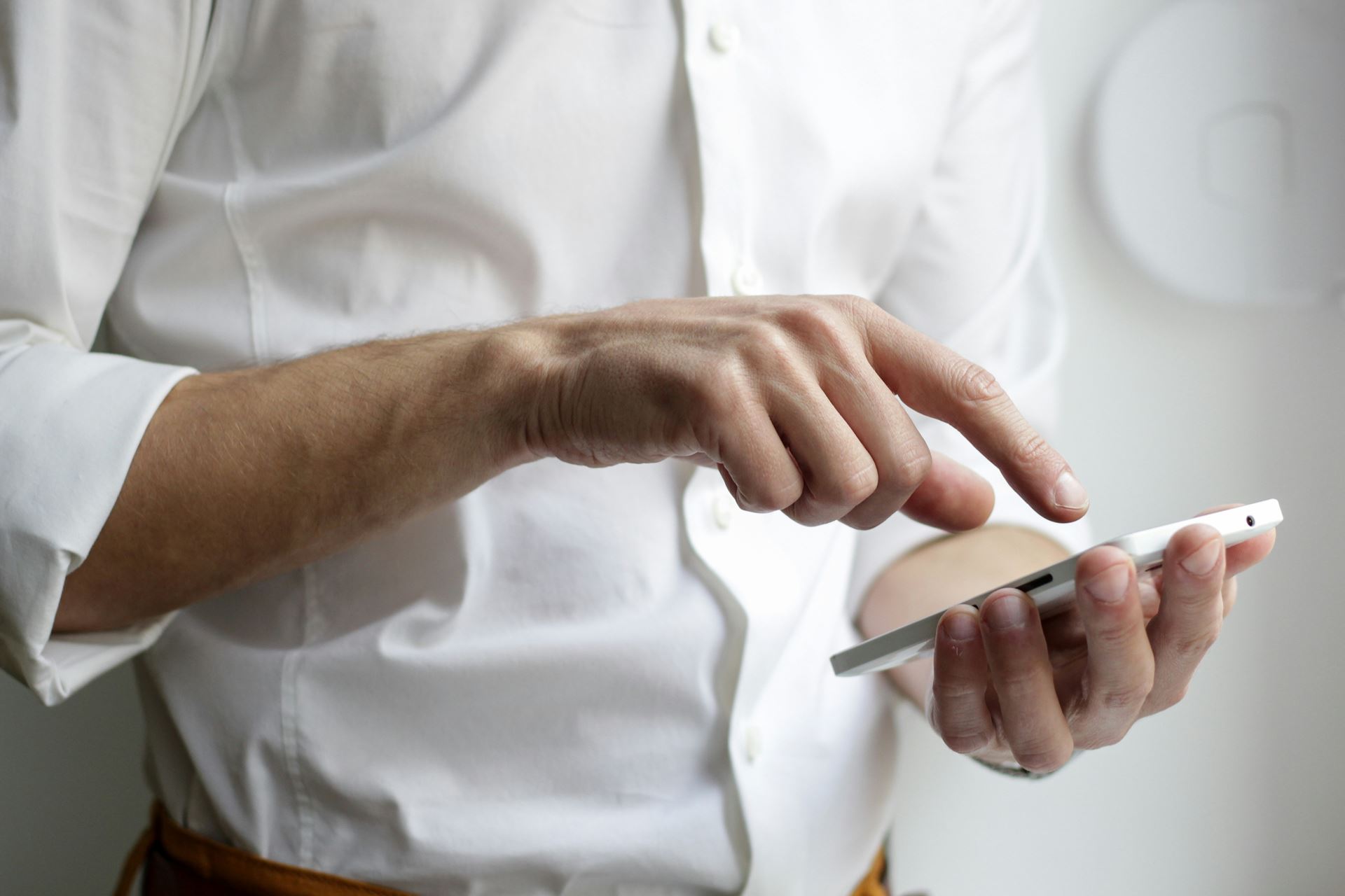 man using a mobile phone wearing a white shirt